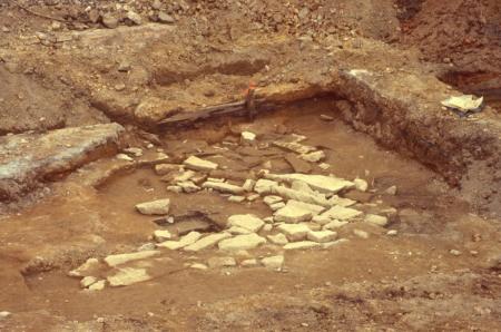 Flat paving stones are exposed in an excavation unit