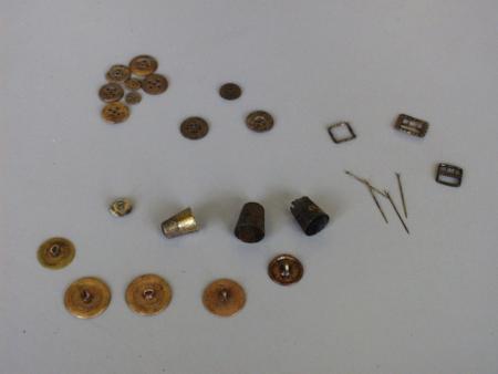 A small assortment of thimbles, pins, buckles, and buttons