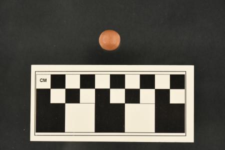 A brown clay marble, approximately 1.5 cm in diameter