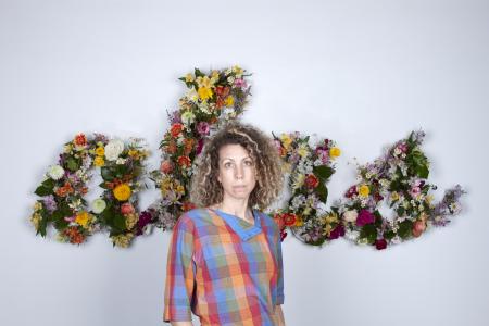 Photo of Alicia Eggert in front of her artwork