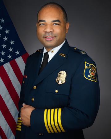 Portrait of Chief Tarrick McGuire in his dress uniform with an American flag in the background.