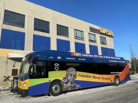 Bus parked on side of building with picture of Rosa Parks and Freedom Moves Forward