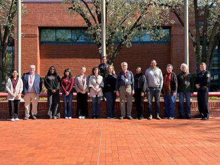 Several civilians standing in a line with the Sheriff to the right and a deputy alone in the second row.