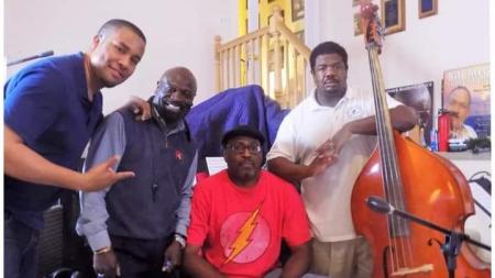 four men standing next to each other with an instrument