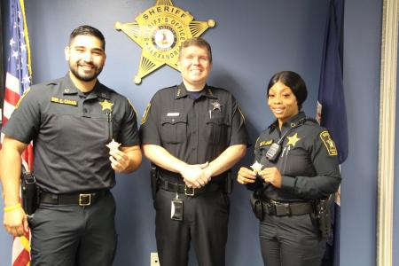 Sheriff Casey Stands with Two Newly Promoted Deputies and Their New Badges to Celebrate Their Promotion