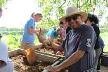 A volunteer holds up an artifact found while screening dirt at the Shuter's Hill Site (44AX175).