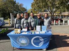 city employee with volunteers tabling at the market
